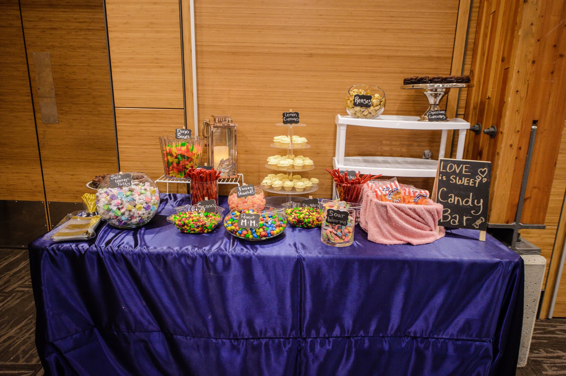 A full Calgary wedding candy buffet with jars, cupcakes, favour bags and a Love is Sweet sign