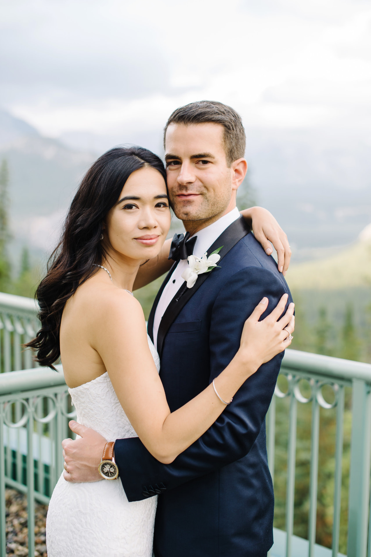 Bride and groom embracing on a terrace above the Bow Valley in Banff