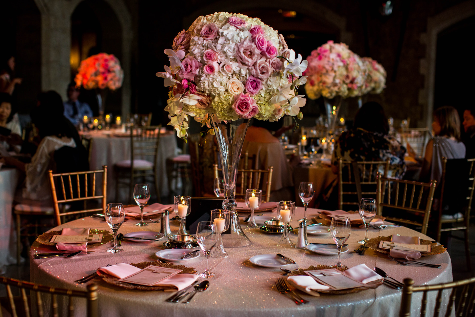Tall blush and ivory rose centrepiece in a candlelit Banff Springs ballroom