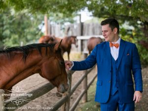 Groom in blue suit, Creative Weddings Planning & Decor, Rocking R Guest Ranch, Bespoke suit, groom and horse, Edward Ross Photography